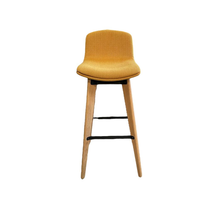 Upholstered yellow bar stools with wooden legs and footrest from the front.