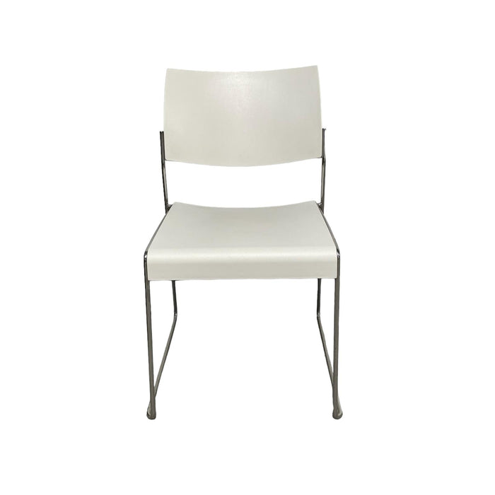 White lino stacking chair with metal legs, from front.