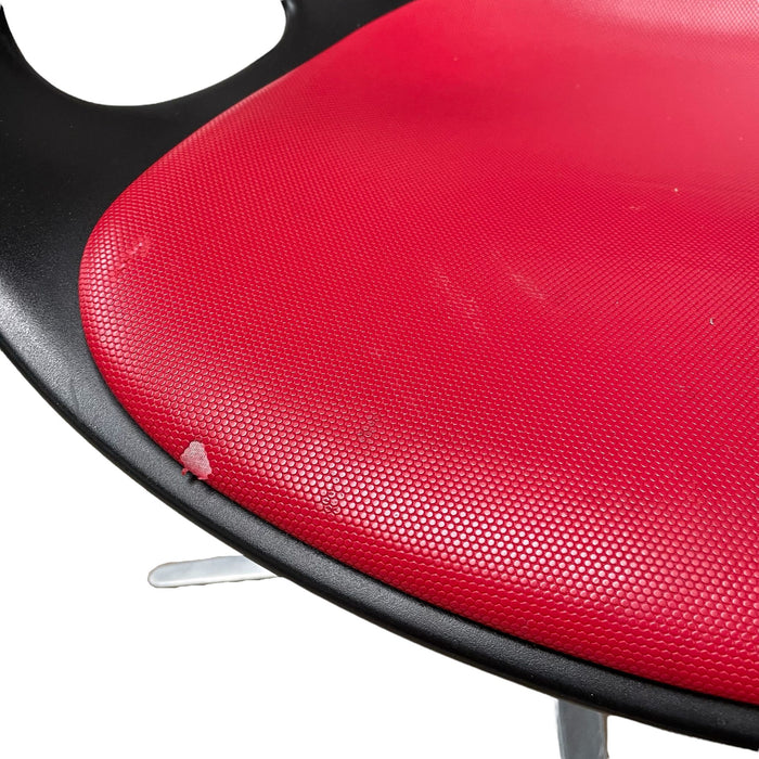 Close up of red and black Fritz Hansen swivel dining chair.