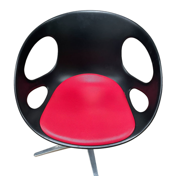 Red and black Fritz Hansen swivel dining chair.