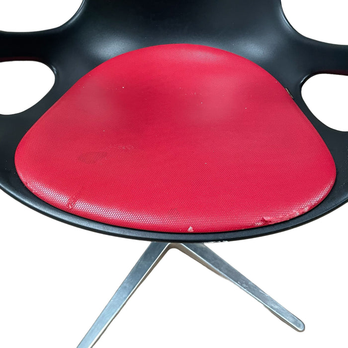 Close up of red and black Fritz Hansen swivel dining chair.