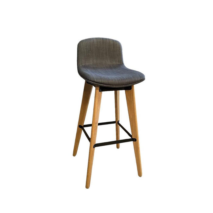 Upholstered grey / blue bar stool with wooden legs and footrest, from the side.