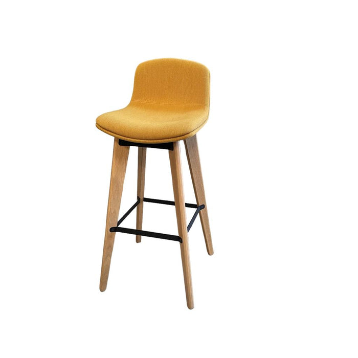 Upholstered yellow bar stools with wooden legs and footrest from the side.