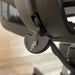 Close up of lever on bottom of graphite Herman Miller mesh office chair.